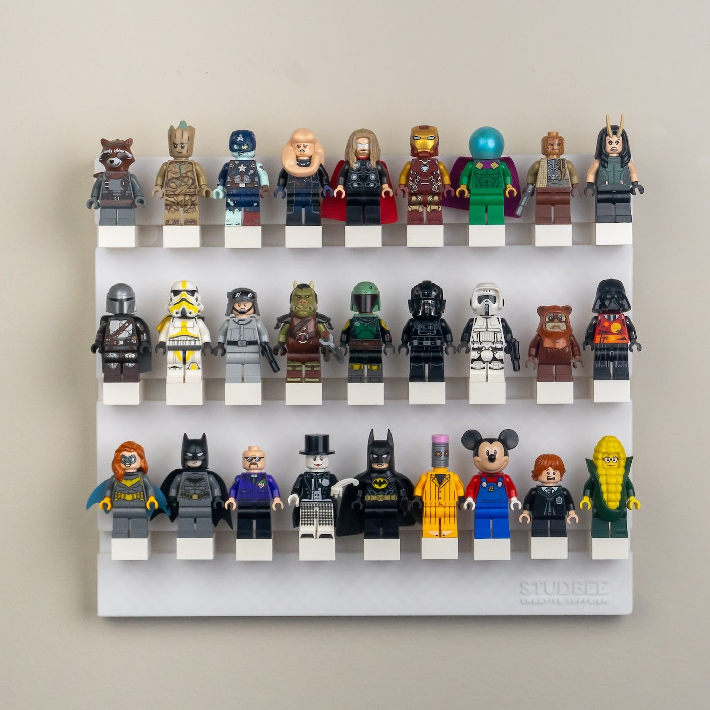 A four-tiered shelf mounted on a wall, filled with colorful character mini-figures, including superheroes and animal-like figures.